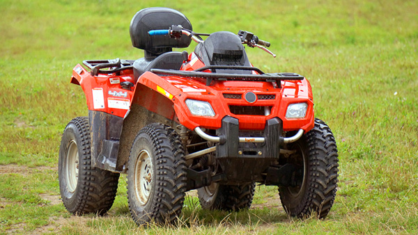 Red ATV running in a field